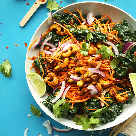 Big bowl of Thai Carrot Kale Salad topped with Curried Cashews