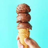 Holding up an ice cream cone with triple scooped homemade Vegan Chocolate Ice Cream