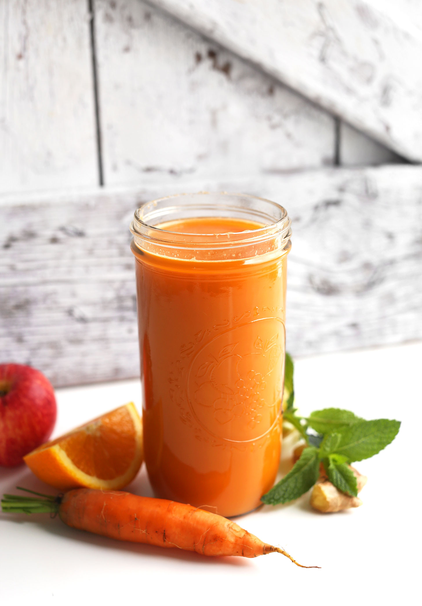 Tall mason jar filled with Carrot Apple Nectarine Ginger Lemon Juice