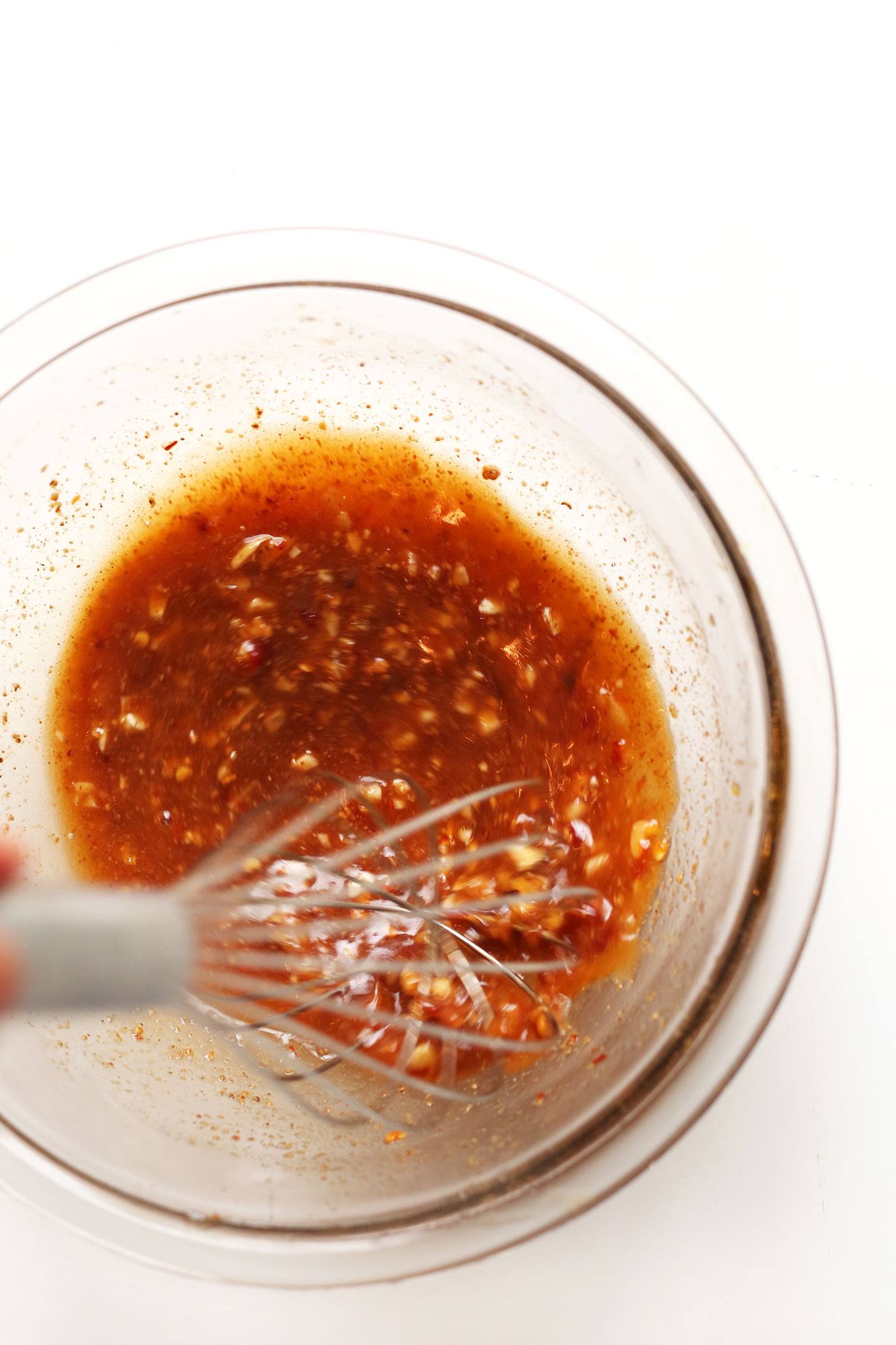 Whisking together an Asian-inspired dressing made with almond butter, tamari, and more
