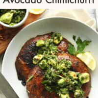 Plate of vegan and gluten-free portobello steaks with avocado chimichurri