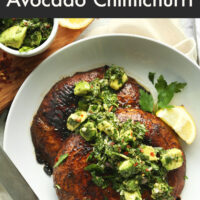 Plate of vegan and gluten-free portobello steaks with avocado chimichurri