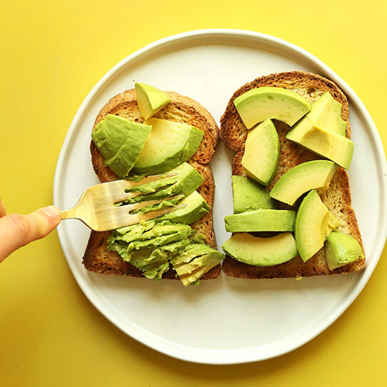 Using a fork to mash avocado on toast