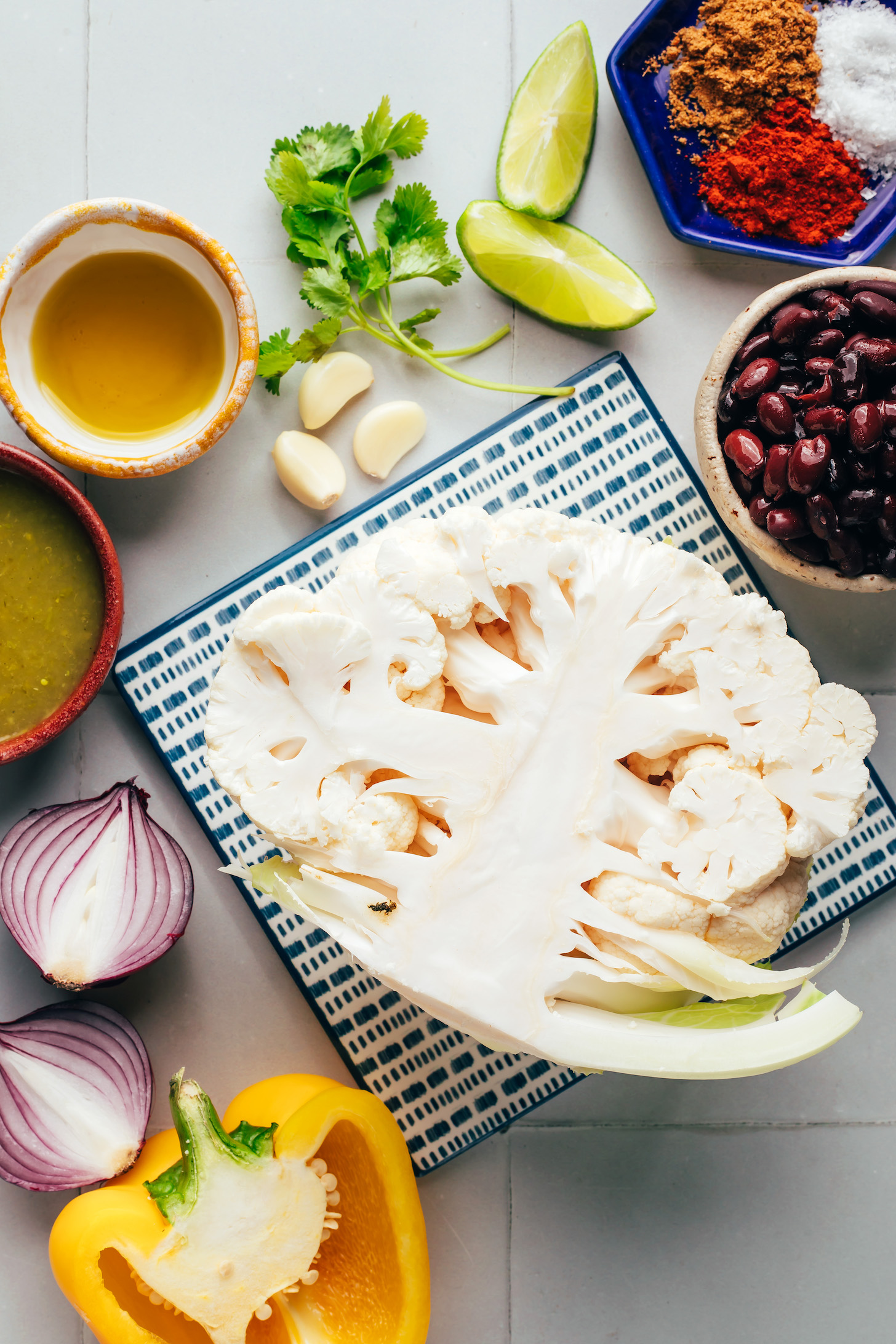 Cauliflower, red onion, bell pepper, salsa, oil, garlic, cilantro, limes, black beans, salt, and spices