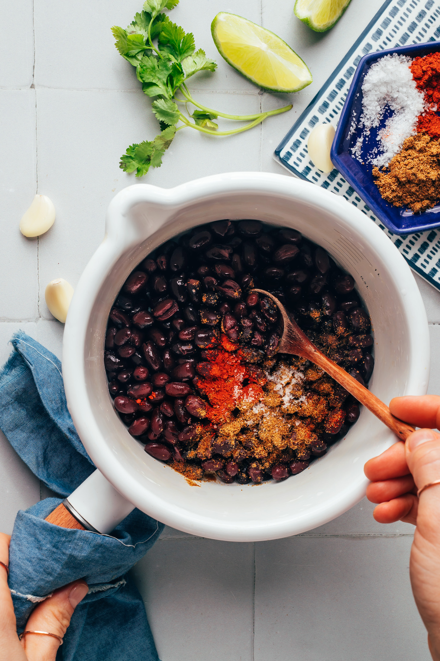 Stirring black beans and spices in a saucepan