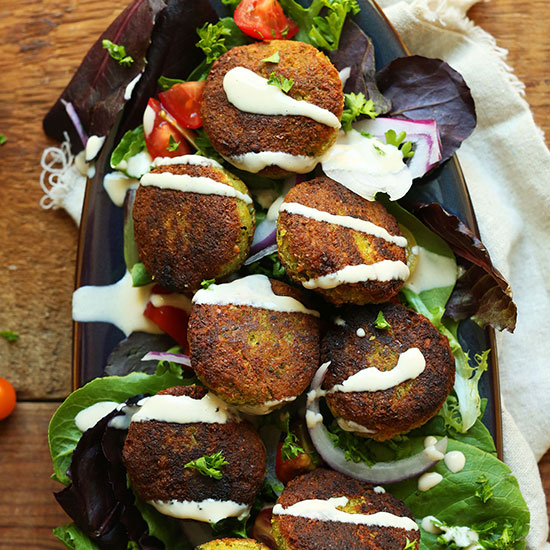 Tray of salad topped with Classic Vegan Falafel and tahini sauce