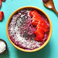 Go-To Vegan Smoothie Bowl topped with shredded coconut, chia seeds, and fresh strawberries