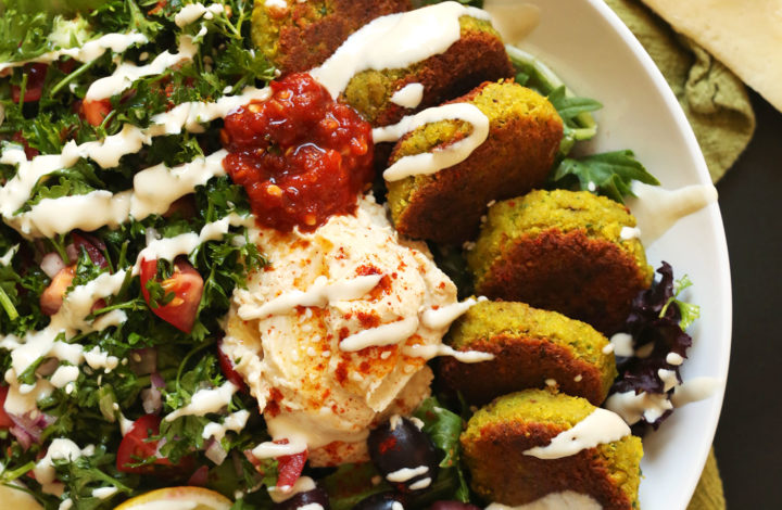 The Ultimate vegan Mediterranean Bowl with hummus, falafel, tahini sauce, olives, and pita