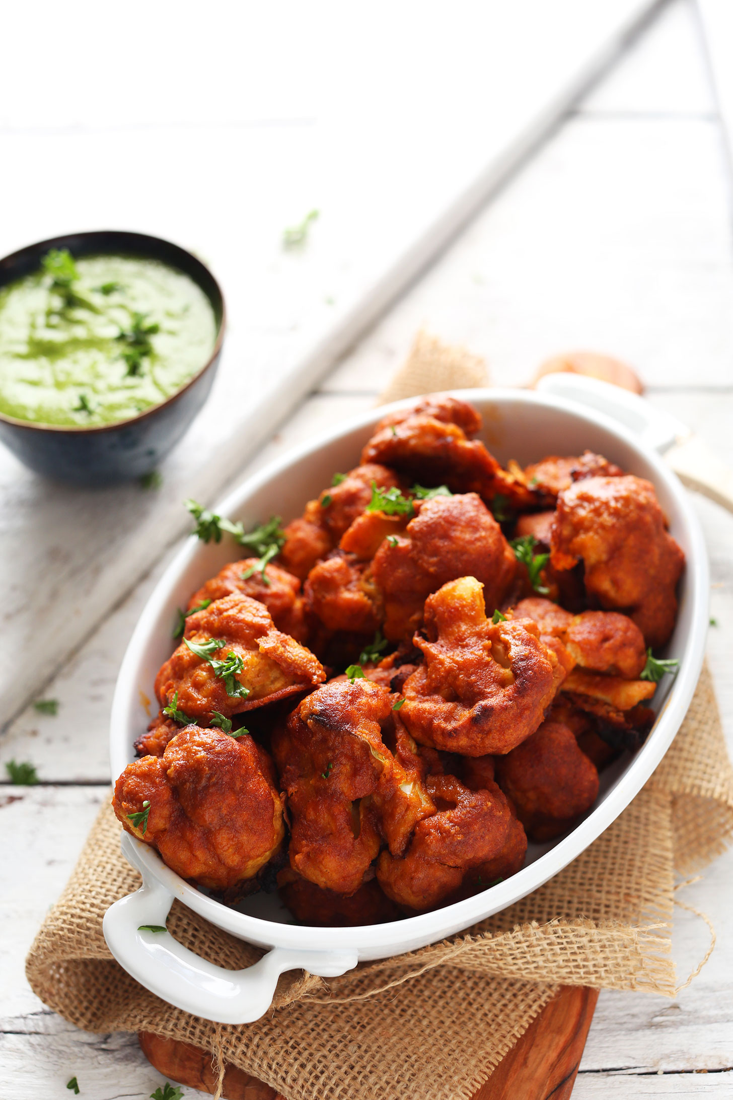 Dish with Red Curry Cauliflower Wings and a bowl of Green Chutney dipping sauce