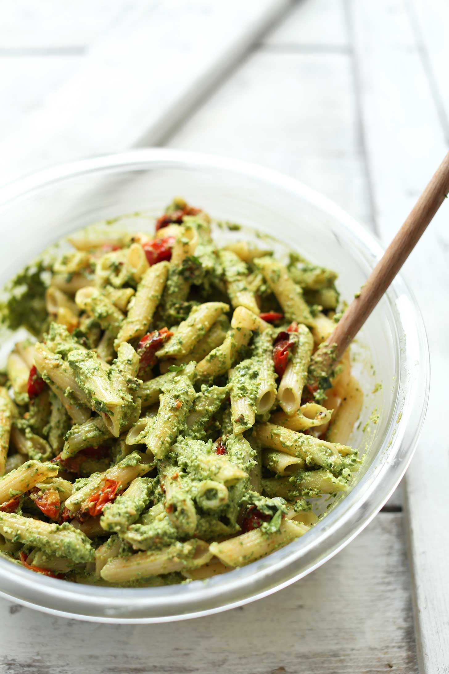 Mixing bowl with gluten-free penne pasta with pesto and cherry tomatoes