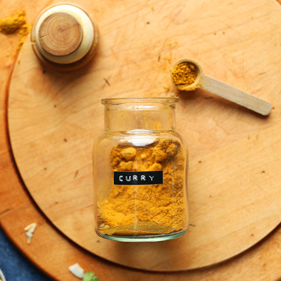 Spoonful and jar of our DIY Curry Powder