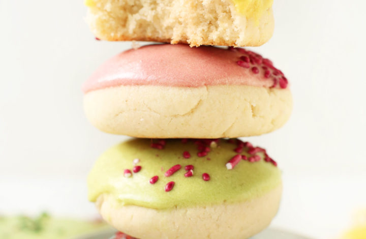 Stack of gluten-free vegan sugar cookies with yellow, pink, green, and blue frosting