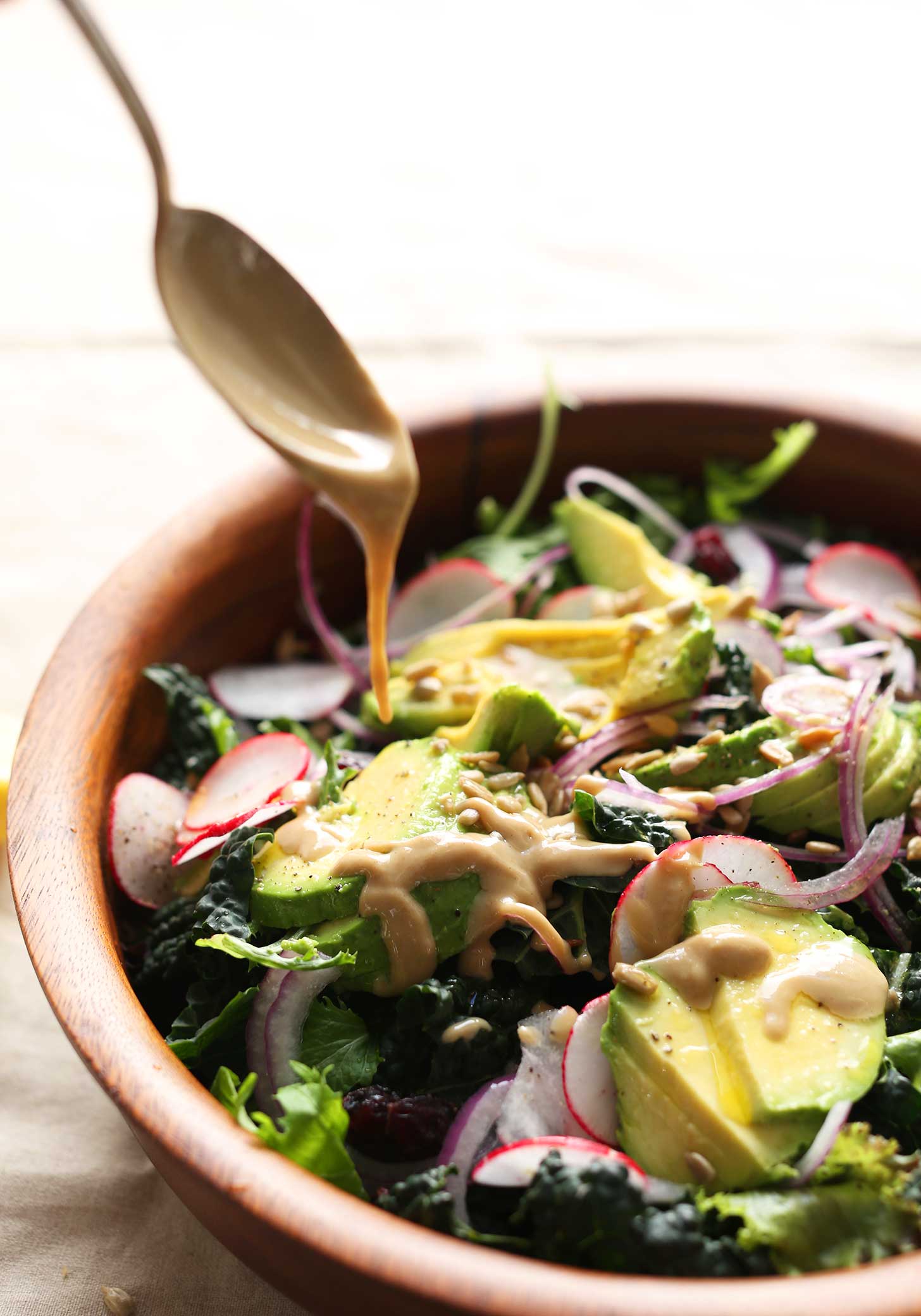 Pouring the easiest homemade no-mix dressing over our detox salad recipe
