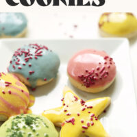 Plate of sugar cookies decorated with icing and sprinkles and text that says fluffy 1-bowl sugar cookies vegan and gluten-free