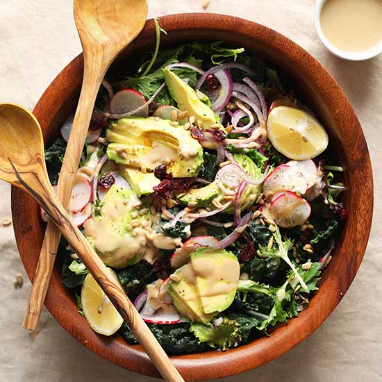 Wooden serving spoons resting on a bowl of Detox Salad