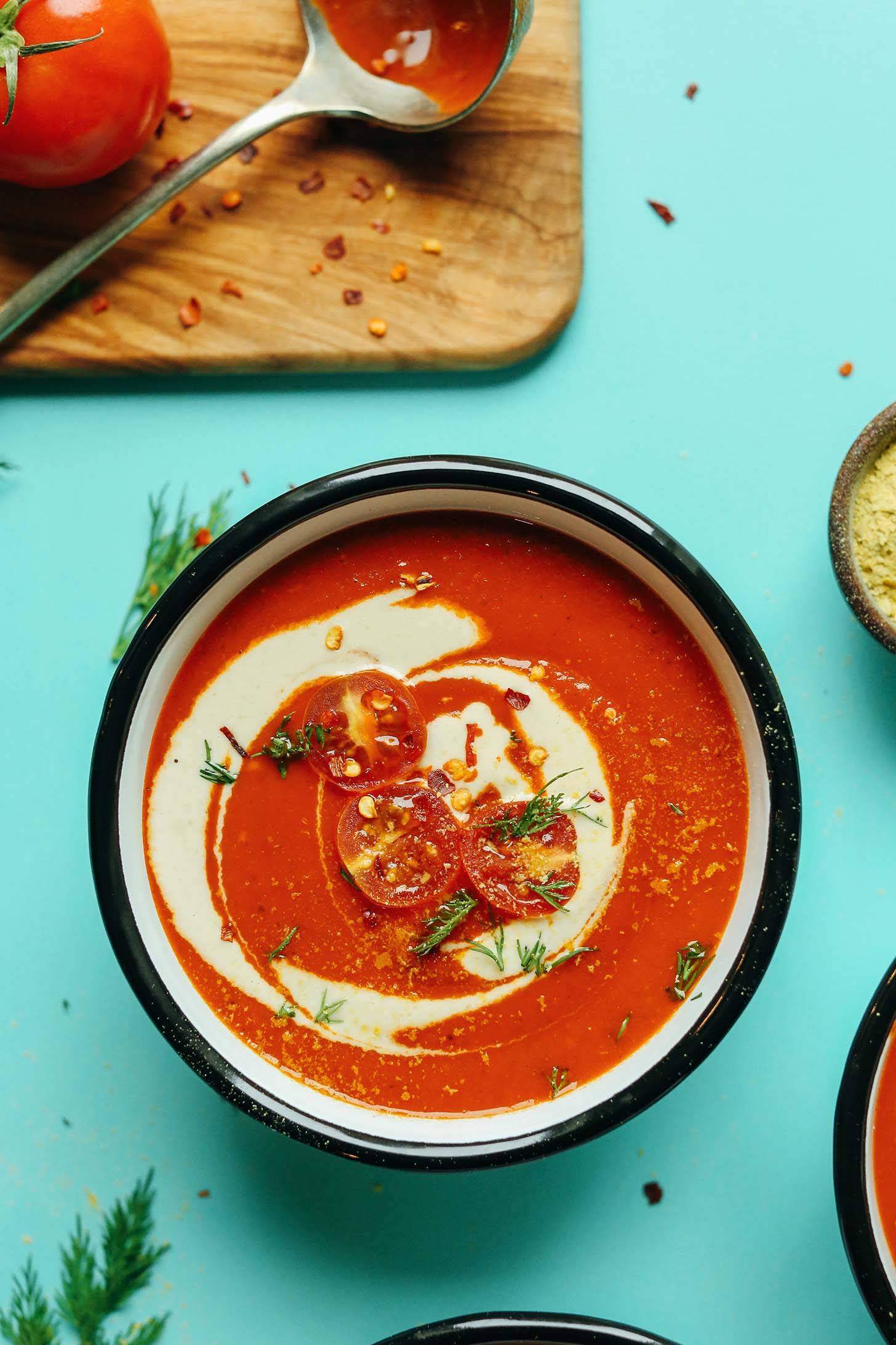 Bowl of Creamy Roasted Red Pepper Tomato Soup that is vegan and gluten-free