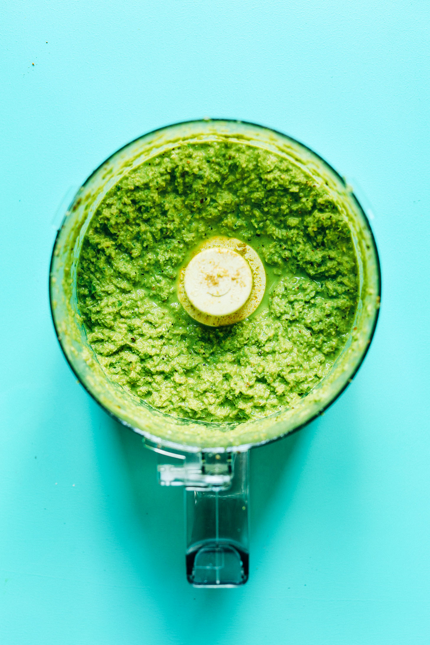 Food processor containing freshly blended ingredients for healthy homemade Green Curry Paste