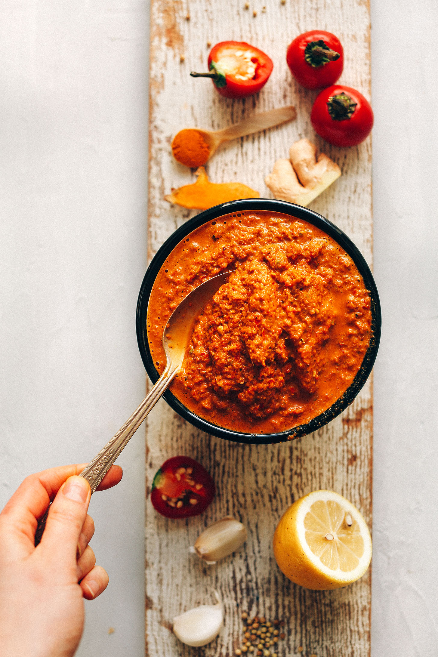 Grabbing a spoonful of our DIY Red Curry Paste for making a flavorful plant-based dish