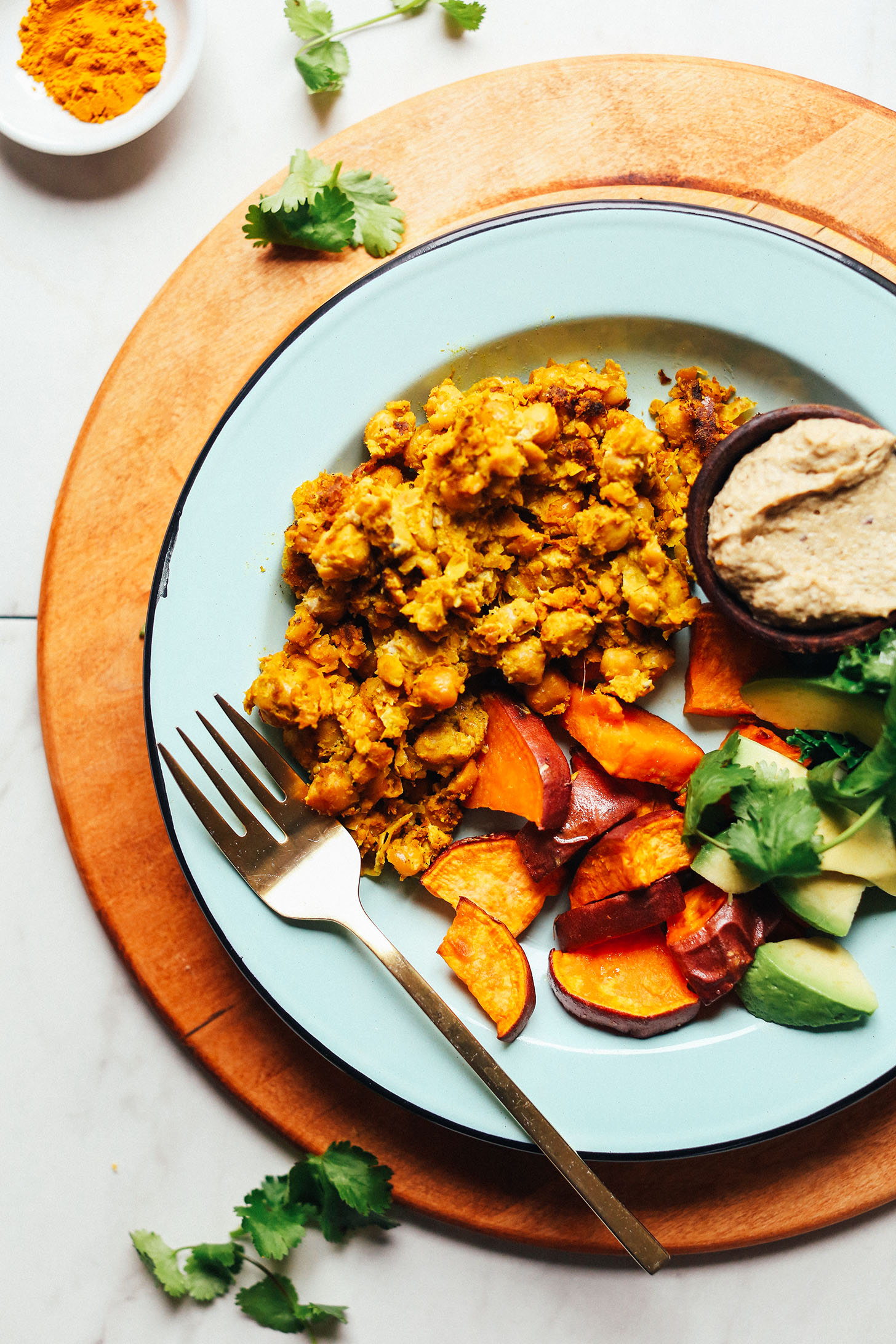 Gluten-free vegan meal of Chickpea Scramble with roasted sweet potatoes, avocado, cilantro, and baba ghanoush