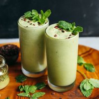 Two tall glasses of our Vegan Mint Matcha Shake for a healthy St. Patrick's Day recipe