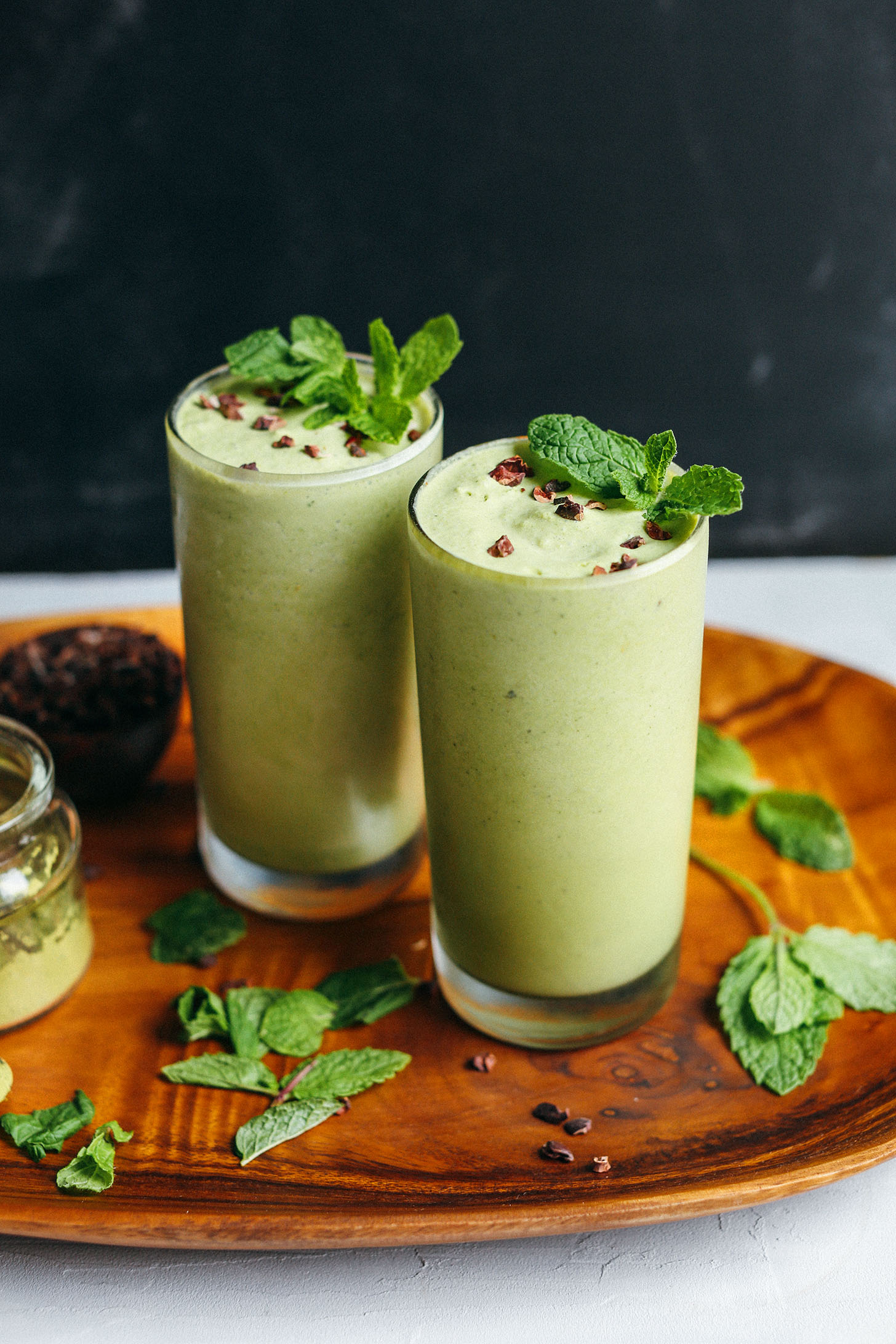 Platter of Vegan Mint Matcha Shakes surrounded by fresh mint leaves