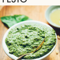Bowl of vegan pesto with text above it saying summer recipe staple 5-minute easy vegan pesto