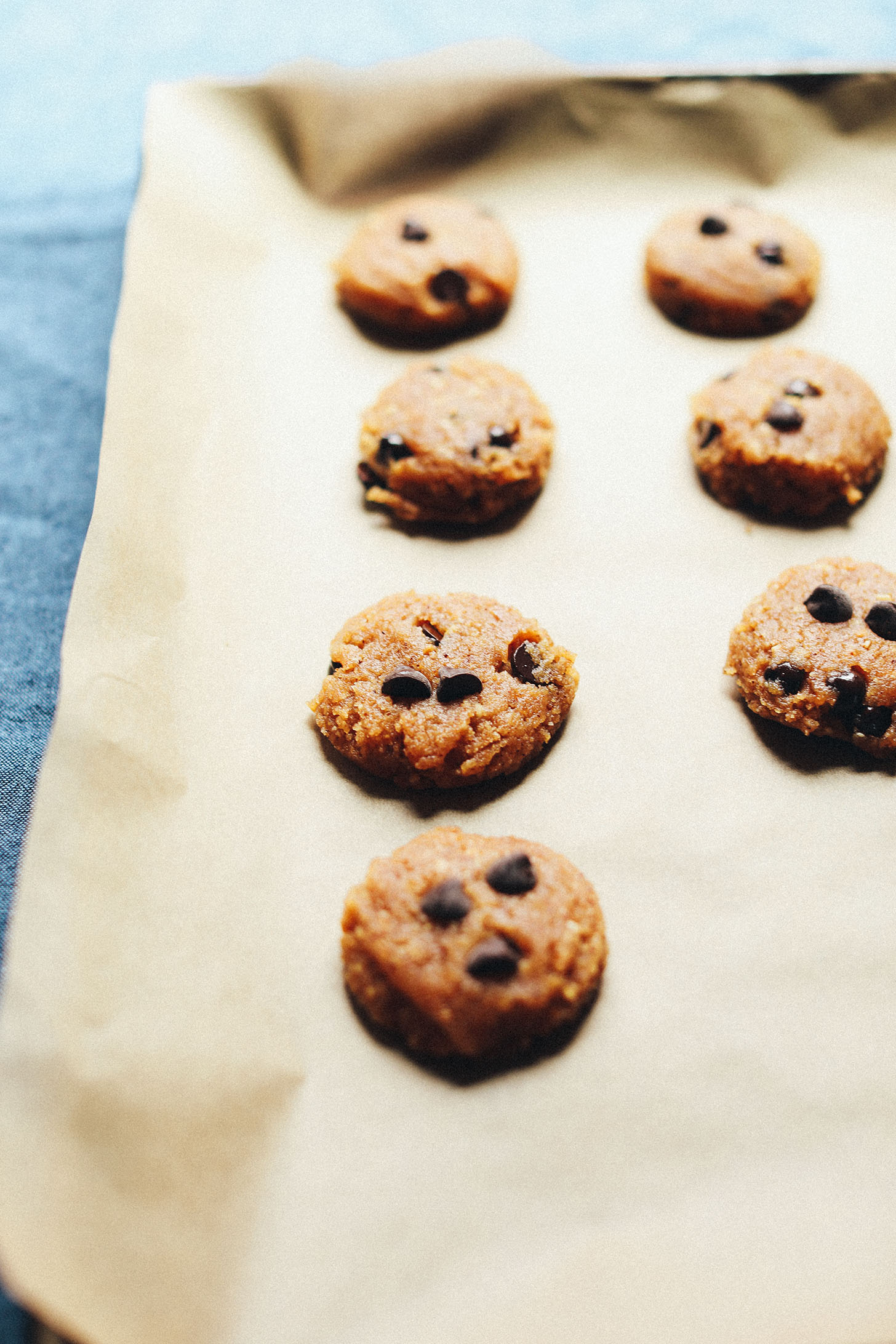 Parchment lined baking sheet with gluten-free vegan Almond Butter Chocolate Chip Cookies