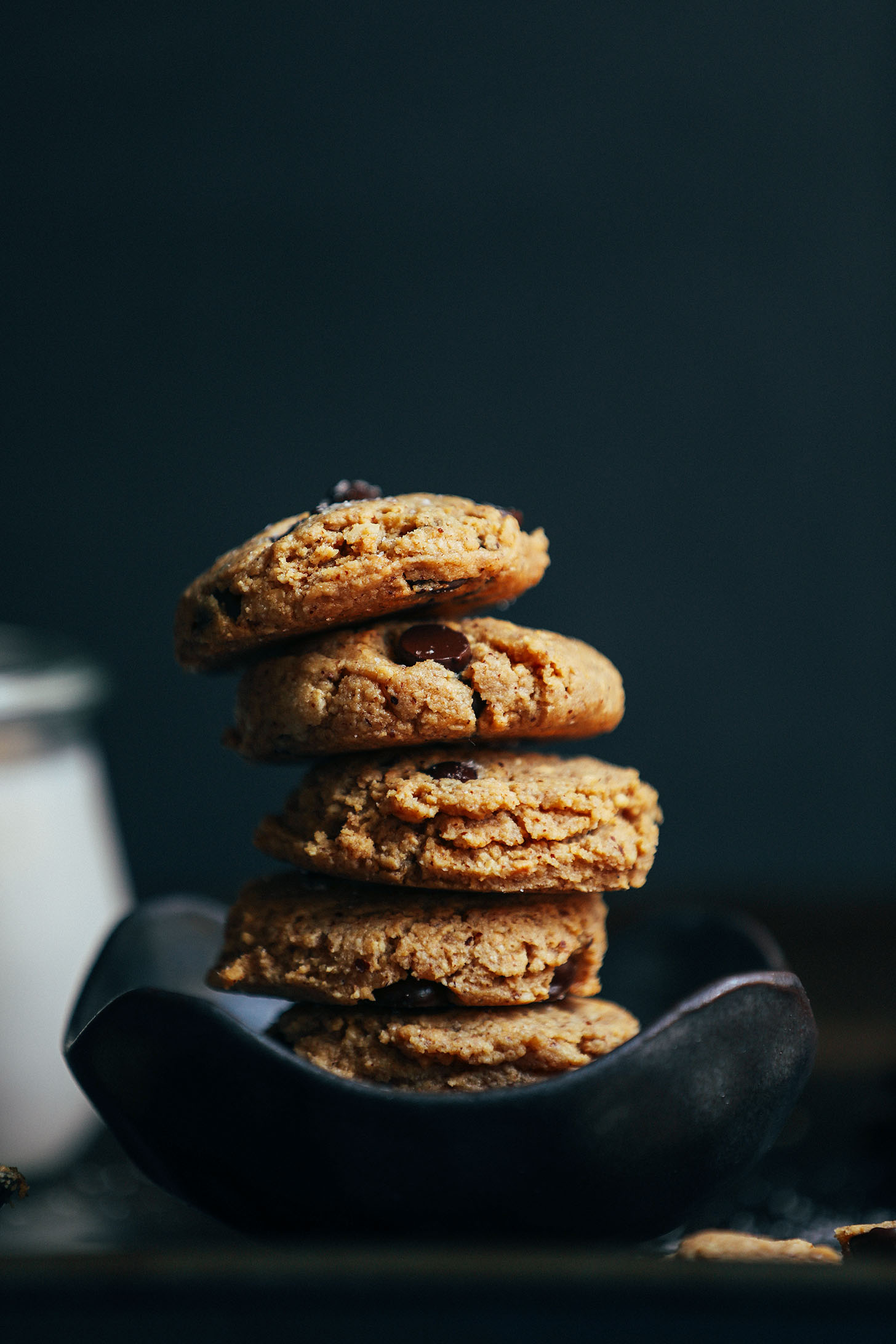A curvy bowl stacked with vegan gluten-free Almond Butter Chocolate Chip Cookies
