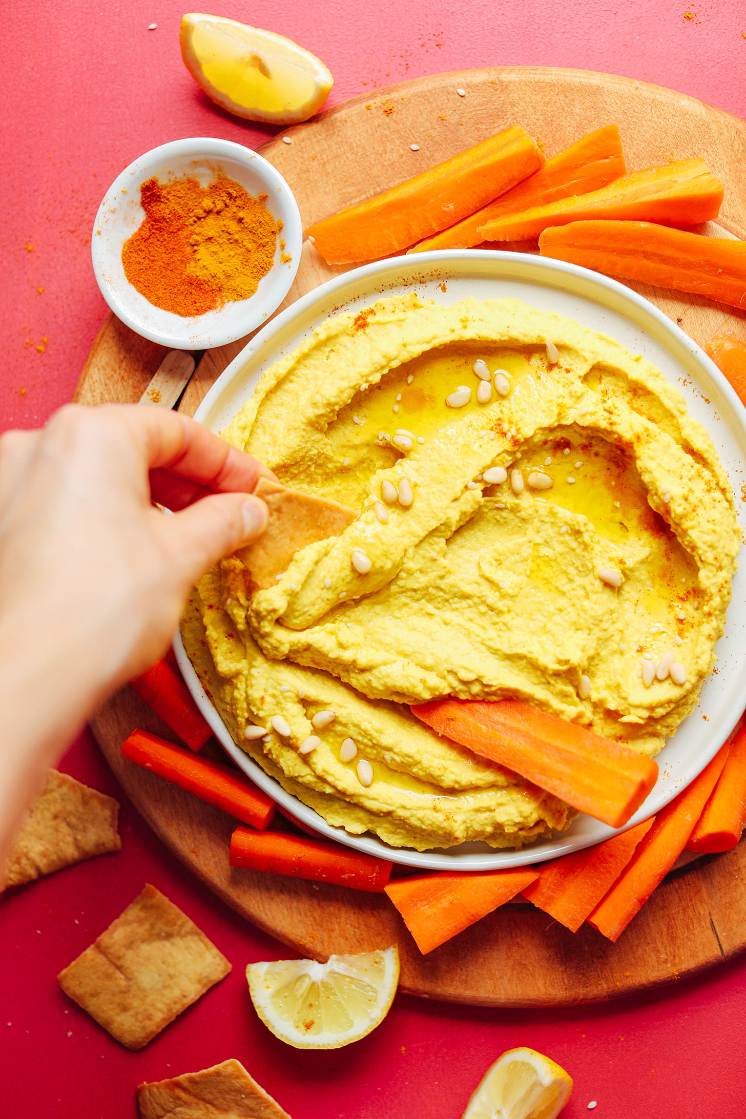 Using a tortilla chip to grab a scoop of Golden Goddess Hummus made with turmeric