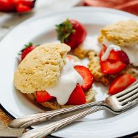 Plate of Two Vegan GF Shortcake Biscuits filled with strawberries and coconut whipped cream