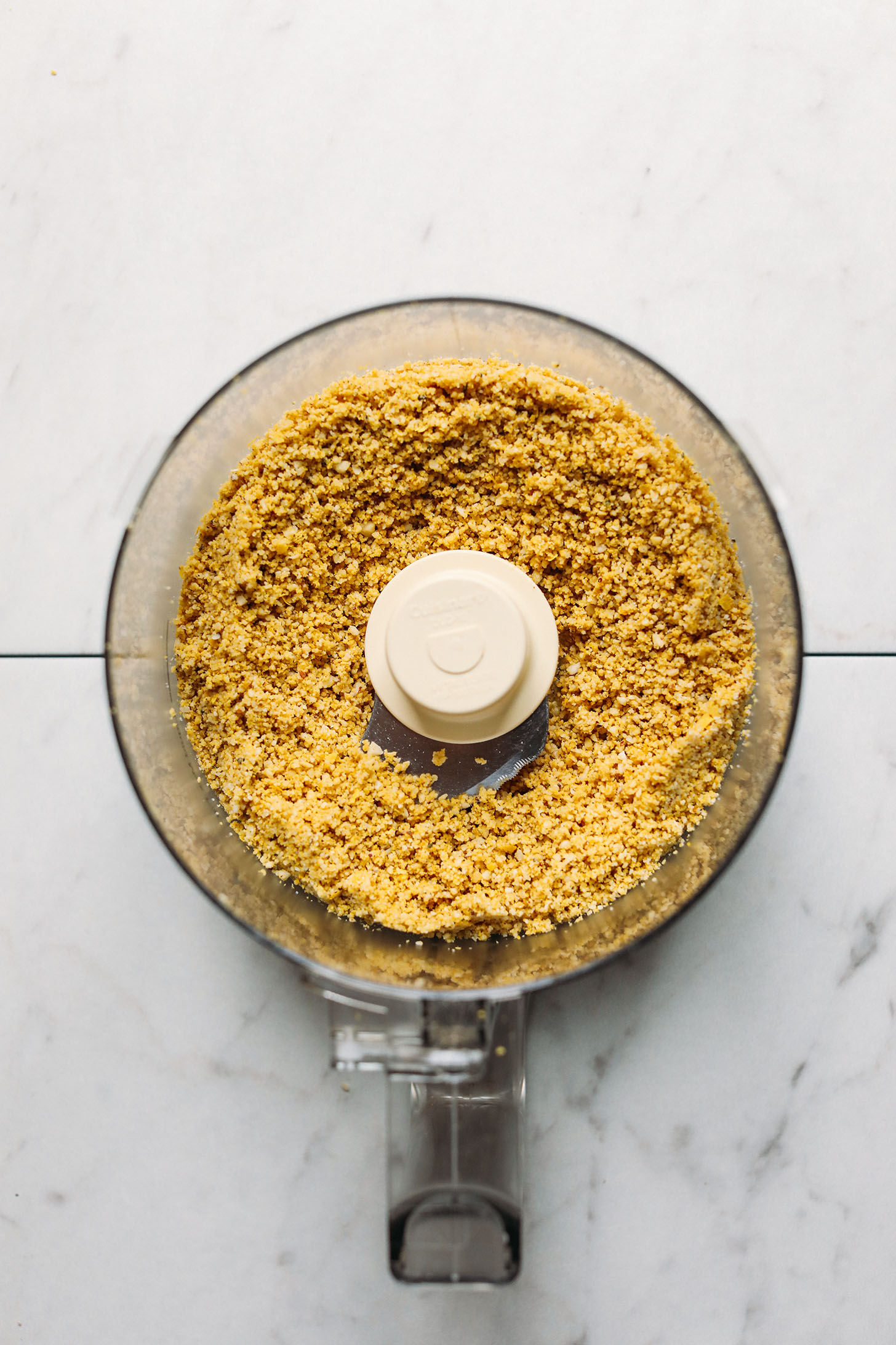 Food processor with Vegan Parmesan made from brazil nuts, hemp seeds, and nutritional yeast