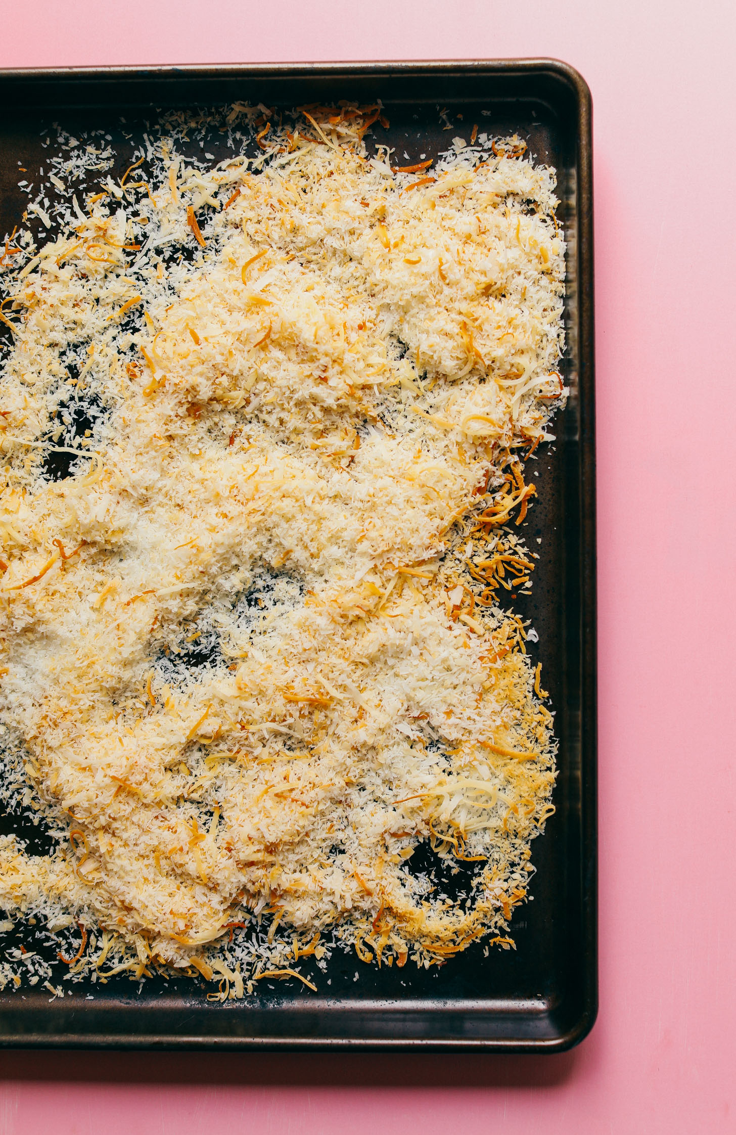 Baking sheet filled with perfectly toasted shredded coconut for making Crispy Vegan Macaroons