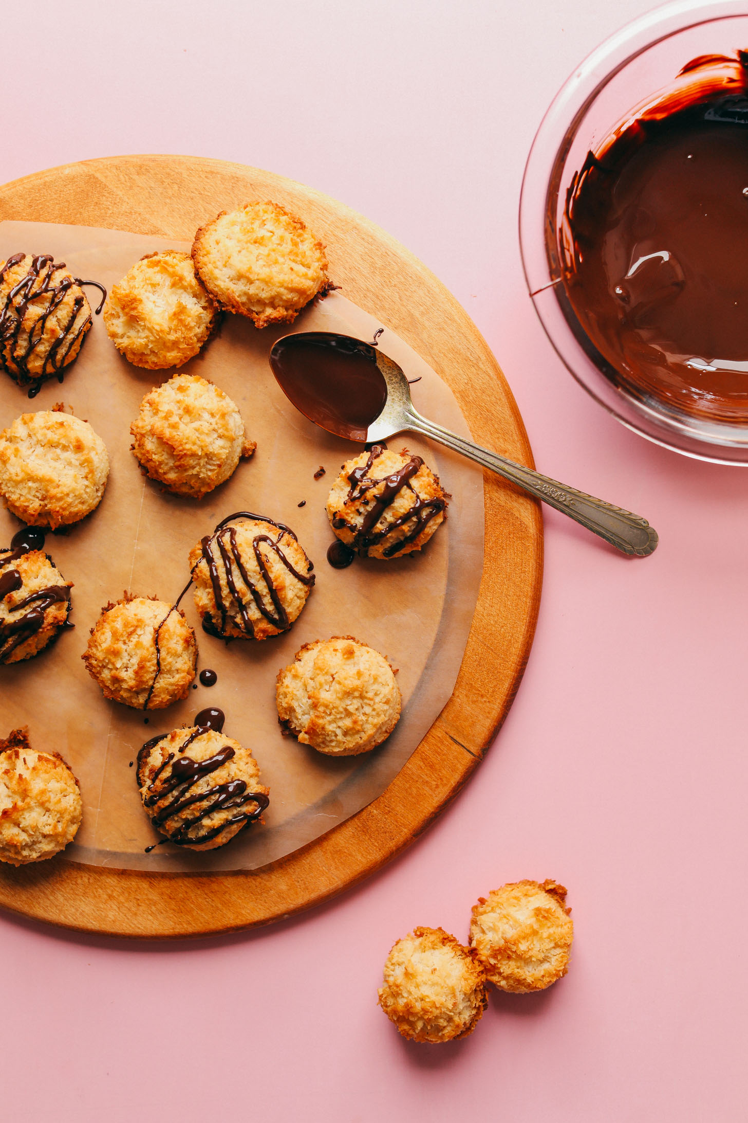 Wooden cutting board with Crispy Vegan Macaroons, some with a chocolate drizzle