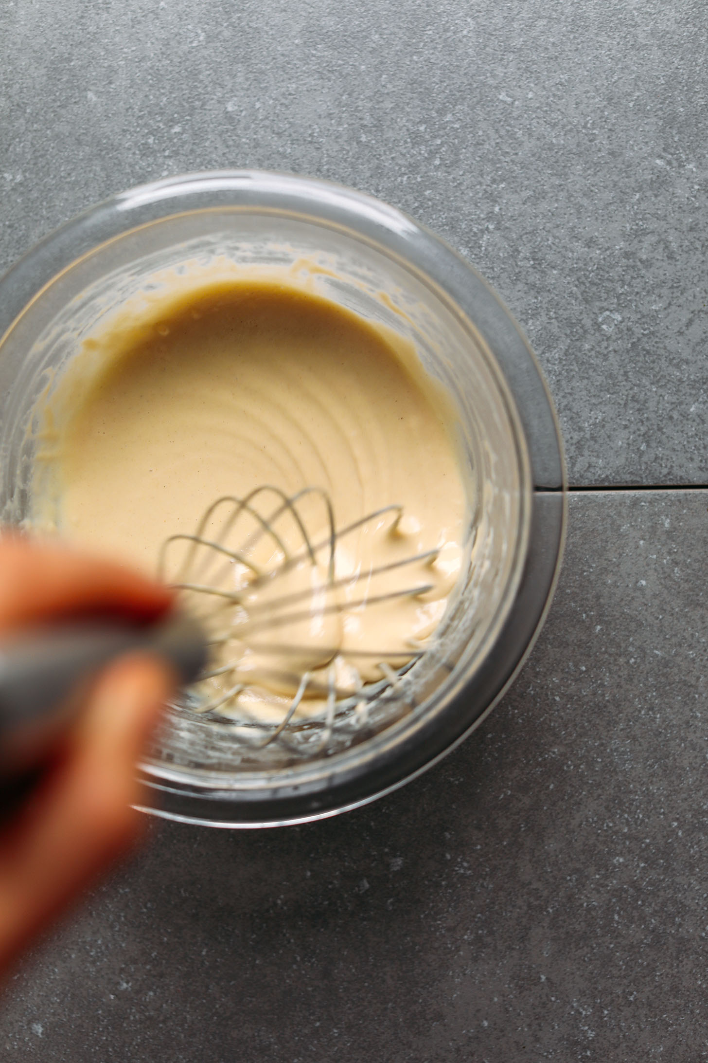 Whisking Tahini Dressing in a small glass bowl