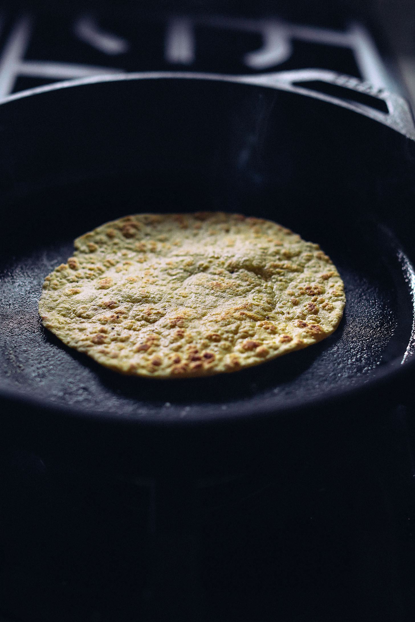 Cooking a grain-free plantain tortilla in a cast-iron skillet