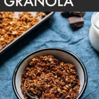 Bowl of vegan and gluten-free sea salt dark chocolate granola with a spoon in it