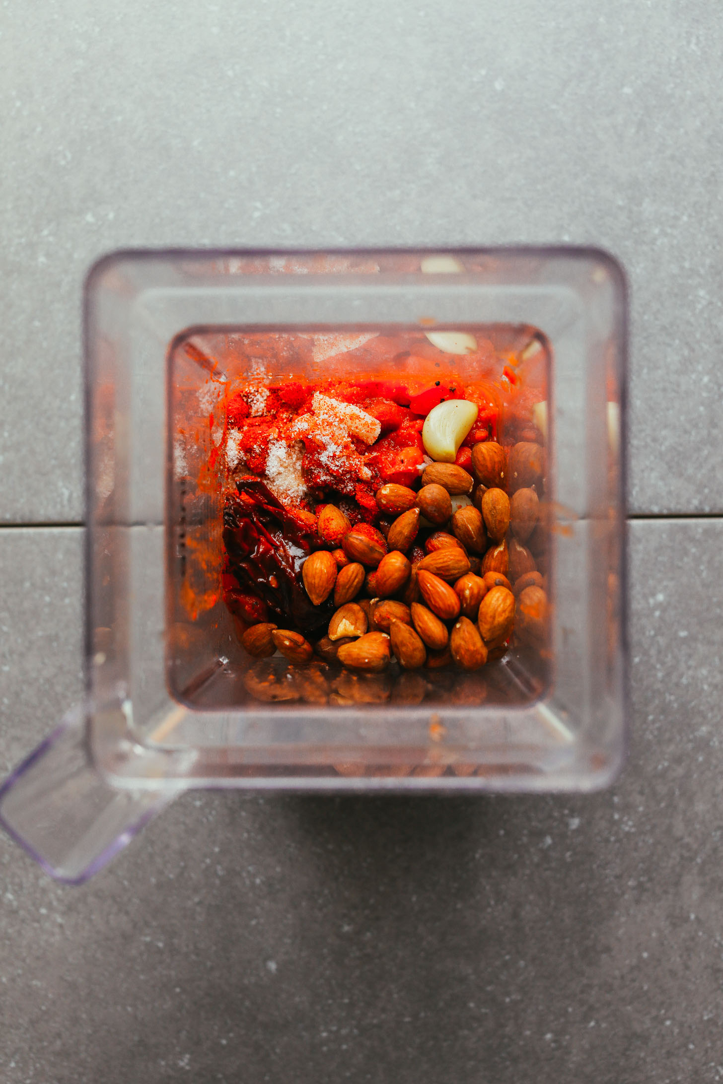 Blender filled with almonds, spices, and other ingredients for vegan Adobo Romesco