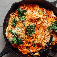 Cast-iron skillet filled with Garlicky Sweet Potato Pasta and Crispy Kale