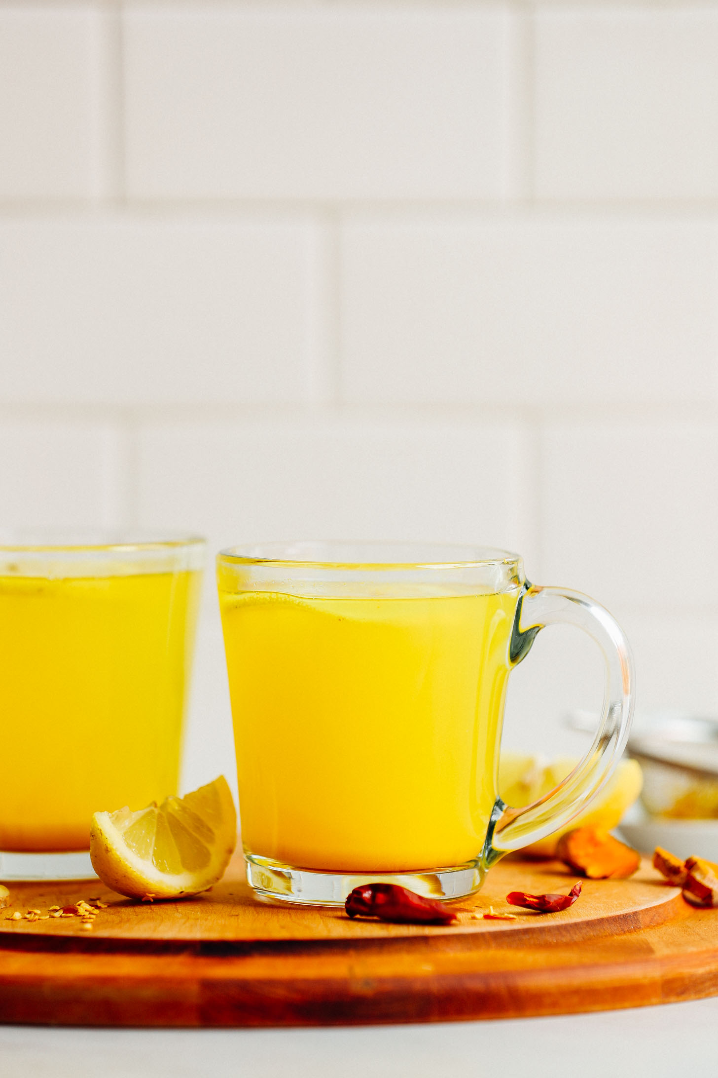 Side view of two mugs of 3-Ingredient Turmeric Ginger TONIC