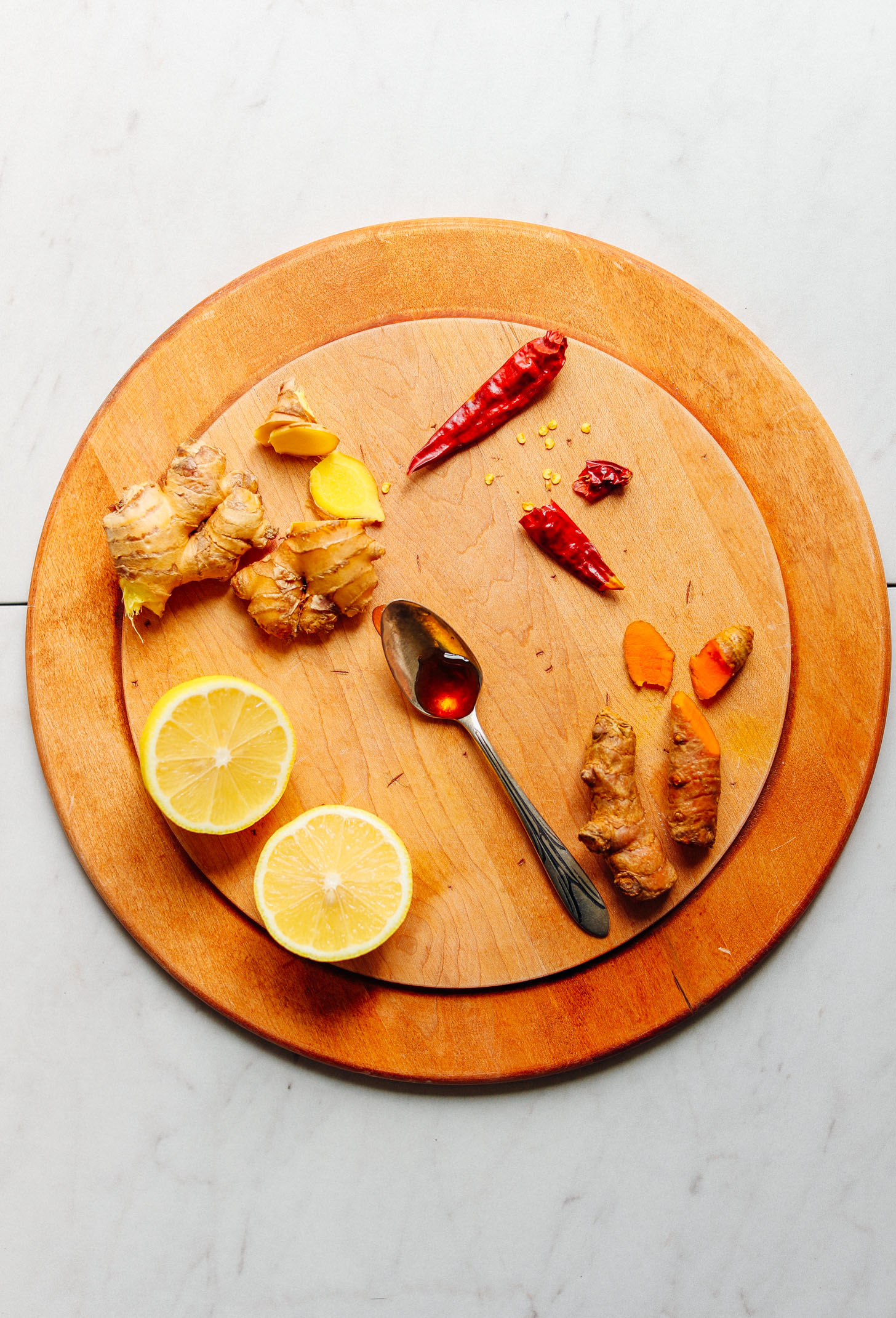 Wood cutting board with ingredients for making 3-Ingredient Turmeric Ginger TONIC