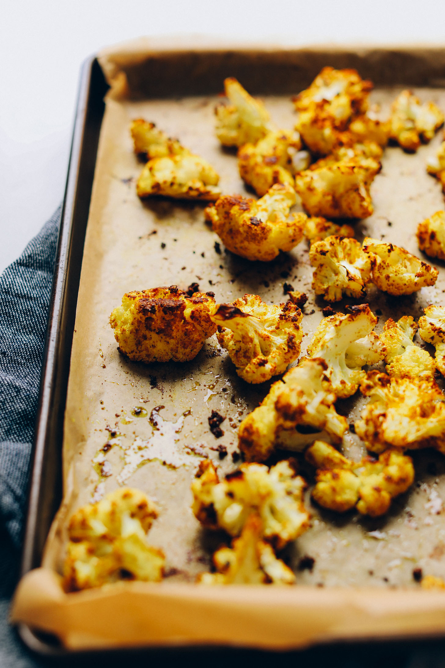 Parchment-lined baking sheet with freshly roasted curried cauliflower