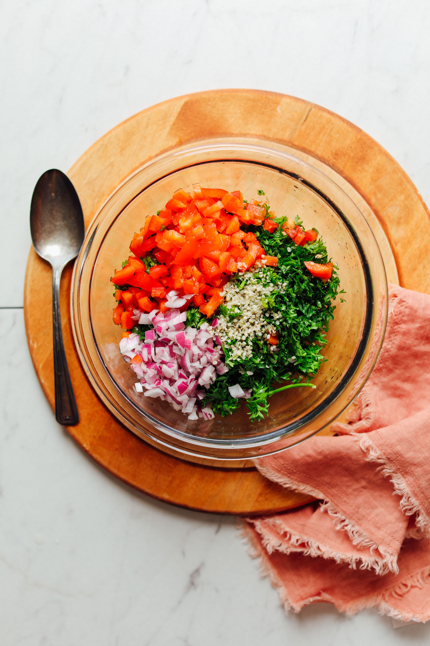 Mixing together ingredients for red pepper hemp tabbouleh to go in our Vegan Greek Bowl