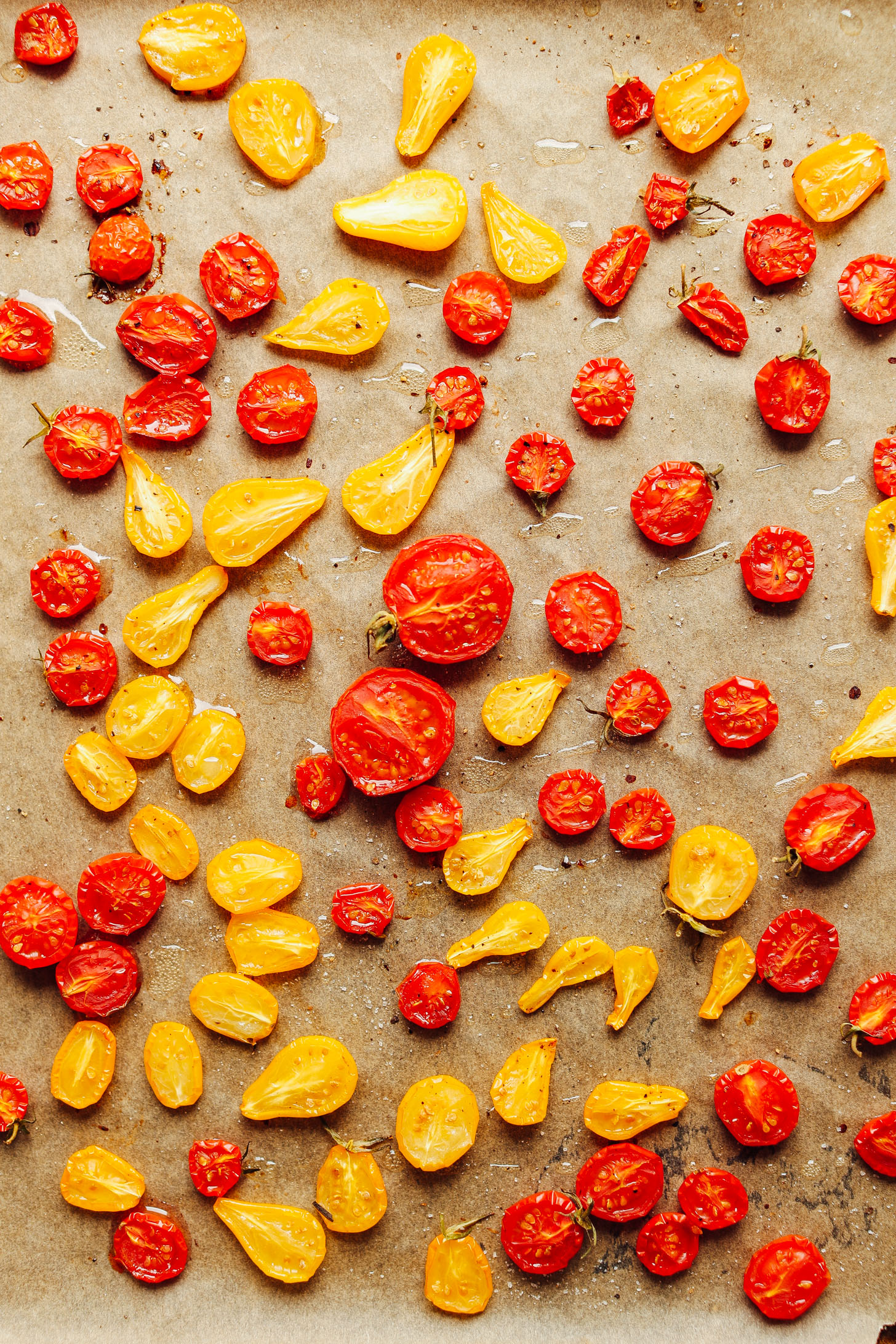 Slow roasted cherry tomatoes on a parchment-lined baking sheet