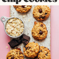Batch of our healthy oatmeal chocolate chip cookie recipe on a wood plank
