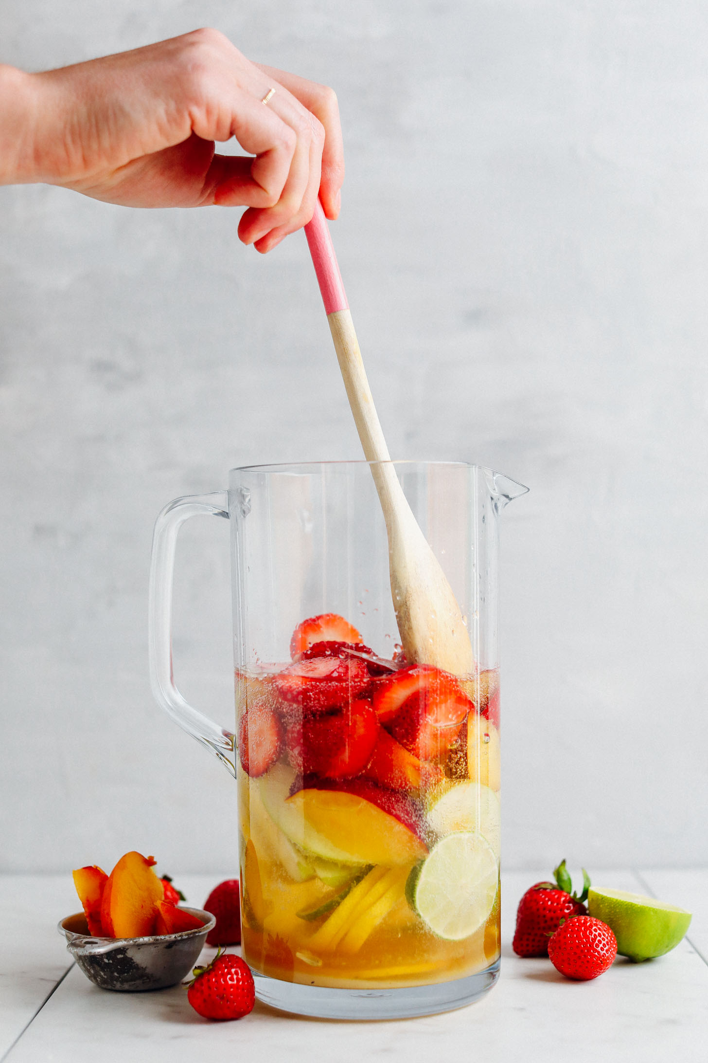 Using a wooden spoon to stir ingredients for Easy Traditional White Sangria