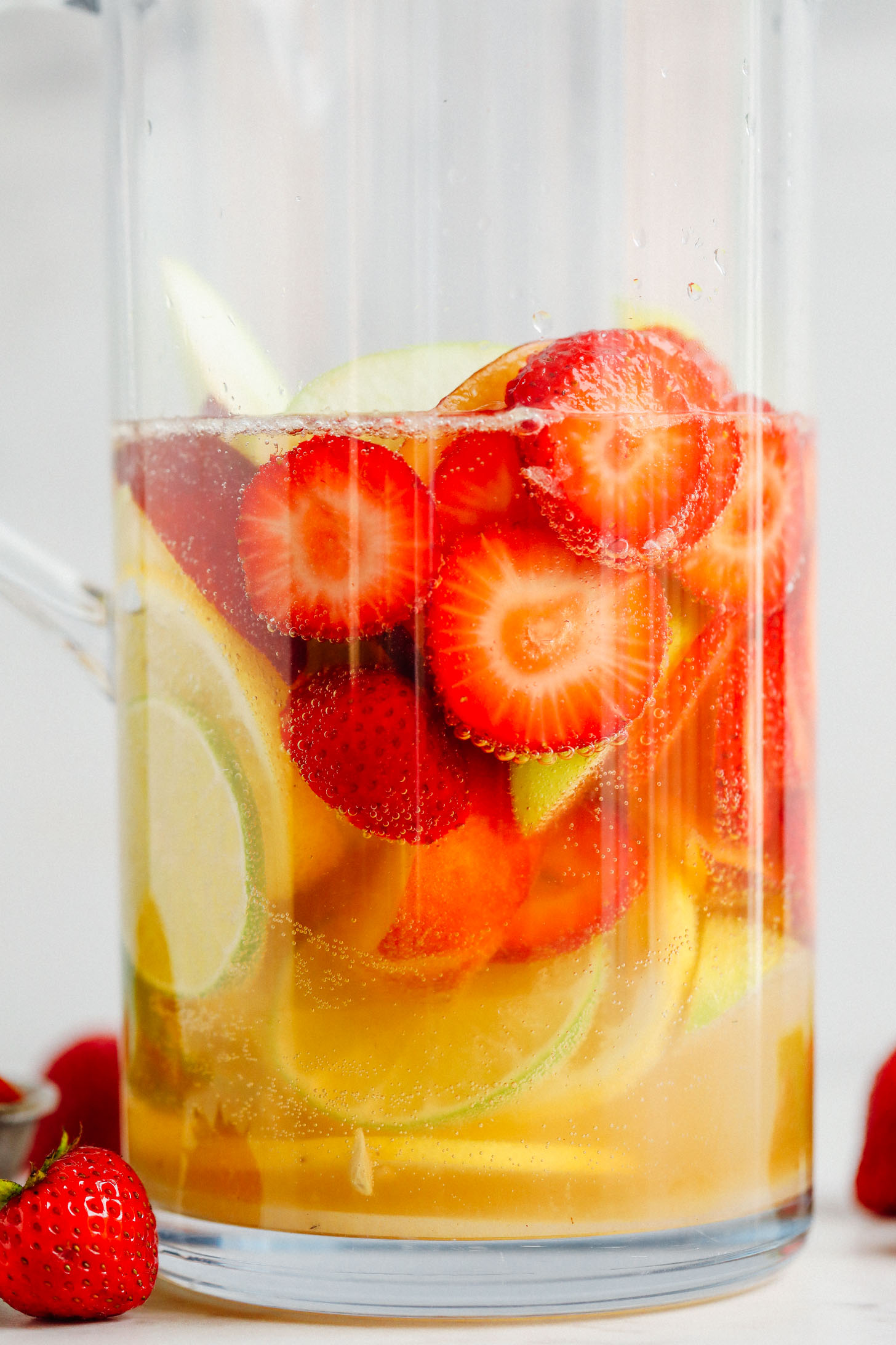 Close up shot of fresh fruit and alcohol in a pitcher for Easy Traditional White Sangria