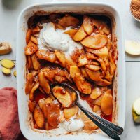 Delicious Cinnamon Baked Apples in a ceramic baking dish with scoops of vegan ice cream