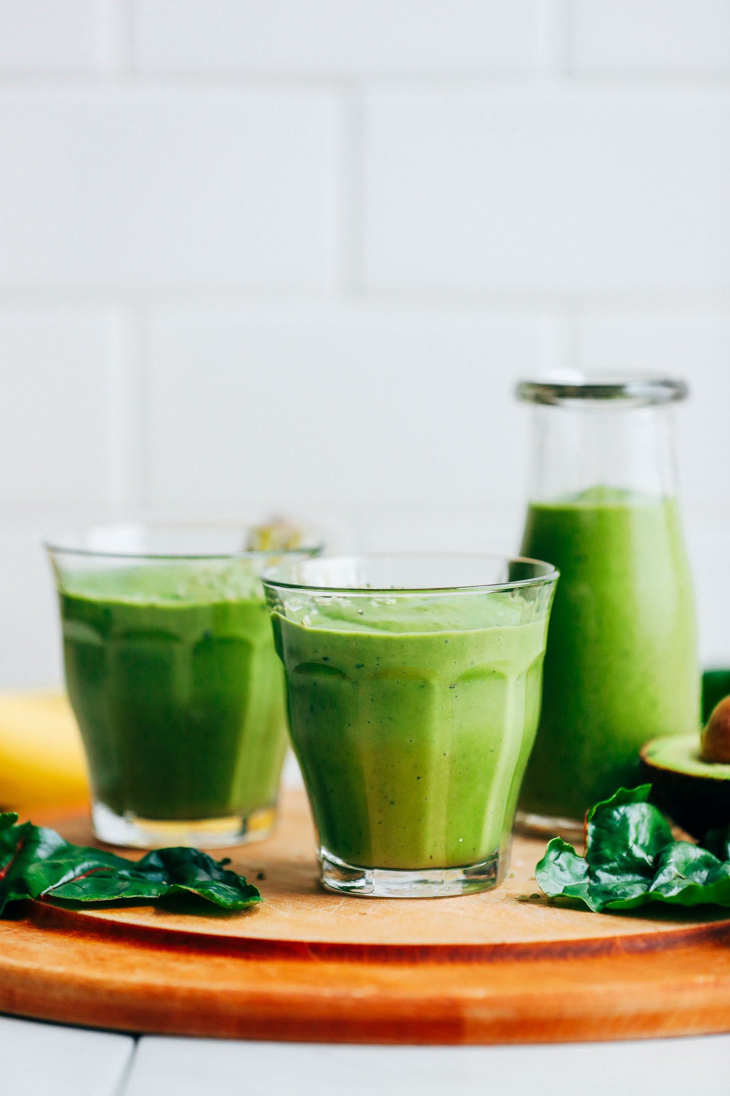 Close up shot of two glasses of our healthy and satisfying Avocado Green Smoothie recipe