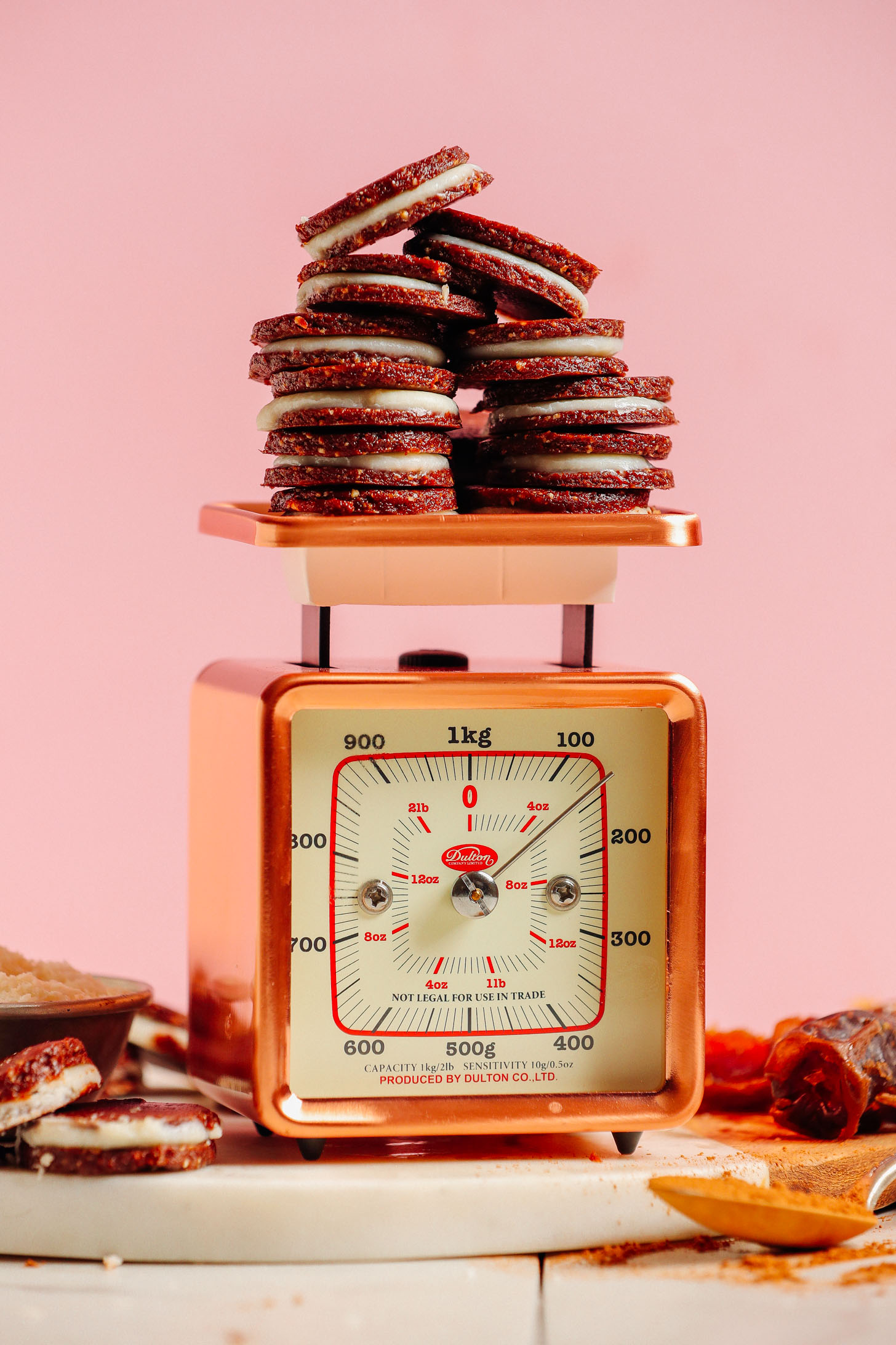 A vintage gold scale holding several gluten-free Raw Oreo Cookies