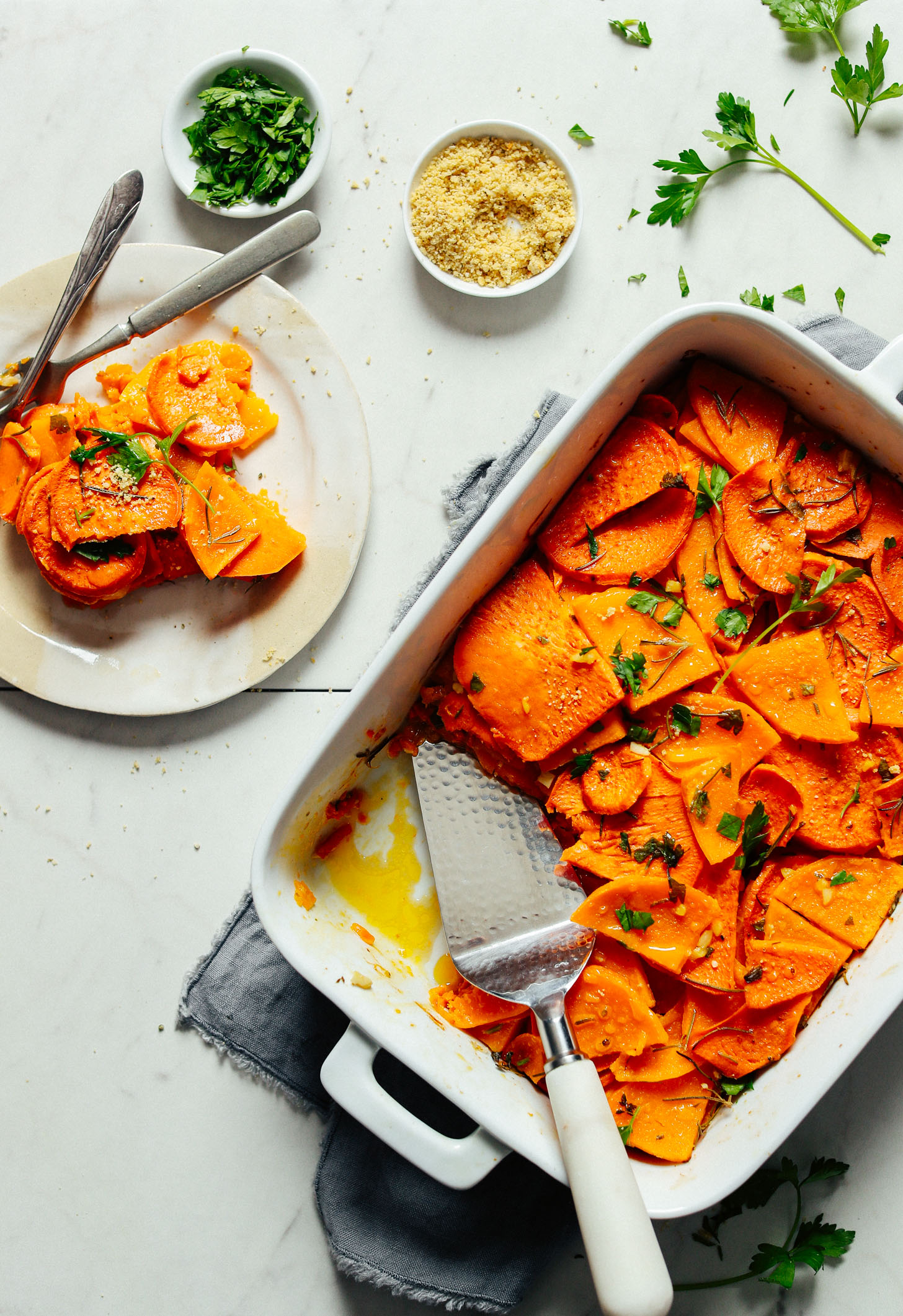 A serving of Vegan Sweet Potato Butternut Squash Tortilla with garnishes all placed beside the whole bake